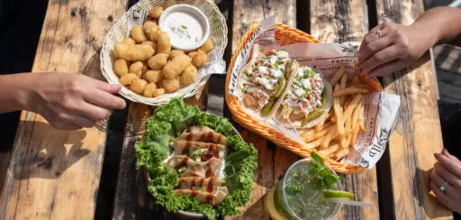 two hand grabbing food on a table