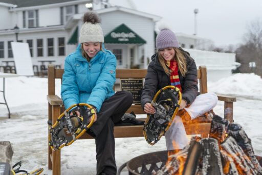 two girls putting on snowshoes