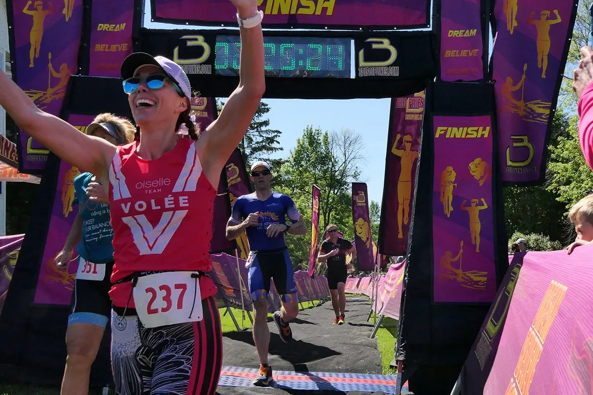 woman running through a race finish line